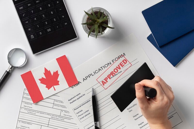 Nigerian student organizing academic documents, including certificates, transcripts, and financial statements, to prepare for a Canadian study permit application.